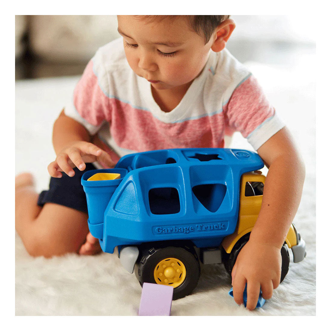 Des jouets verts forment un camion poubelle